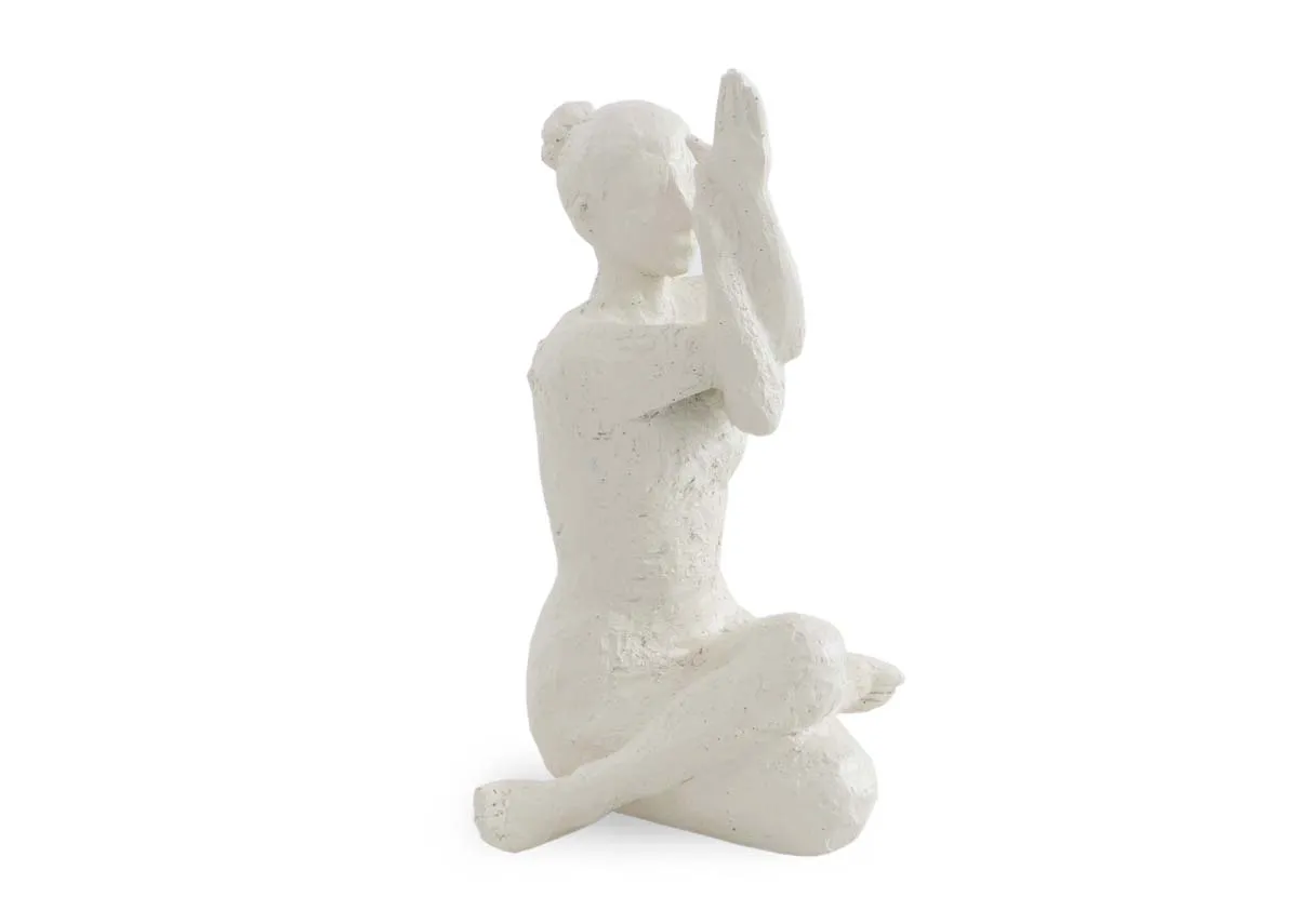 A white ornament shows a femalein a yoga pose. Angled view.