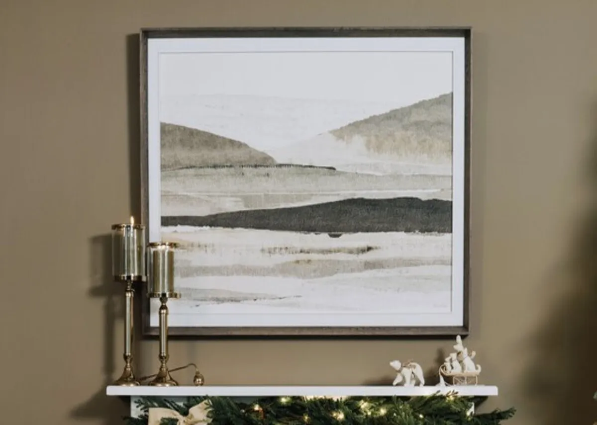 A lifestyle image of the Morning mirage pciture over a white mantle with candle holder.