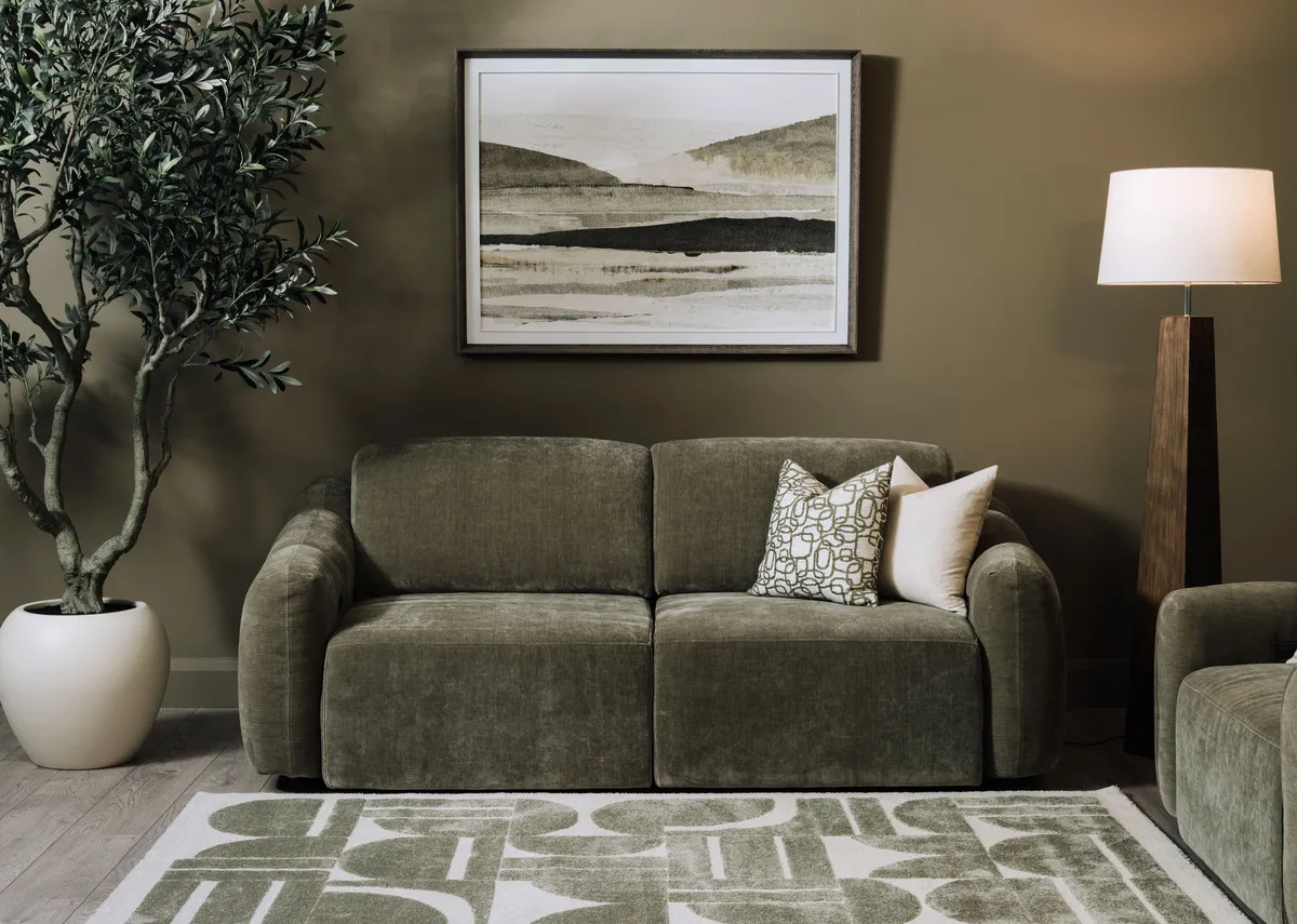 A lifestyle image of the Eleanor green 2 seater with as a sofa with Morning Haze painting and Eleanor armchair.