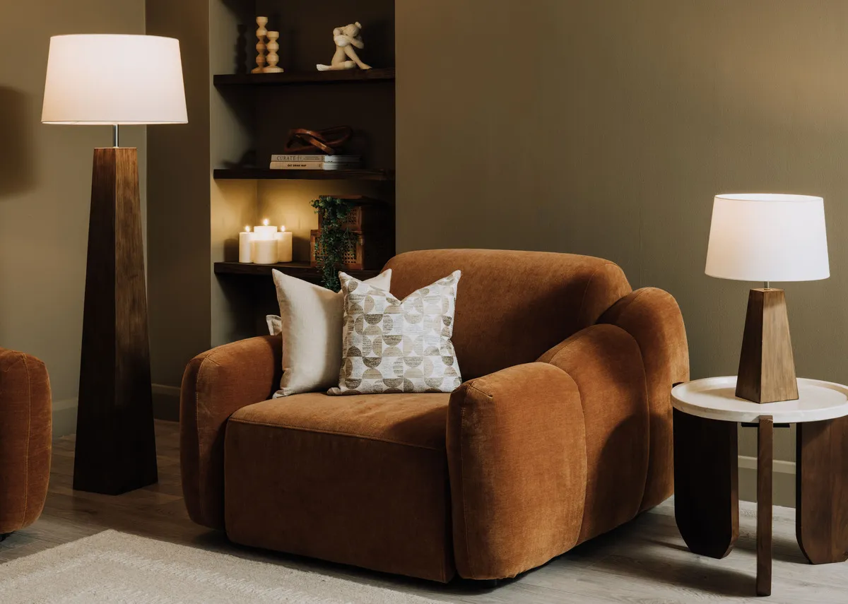 A lifestyle image of the Eleanor rust armchair in fixed mode with Kira tables.