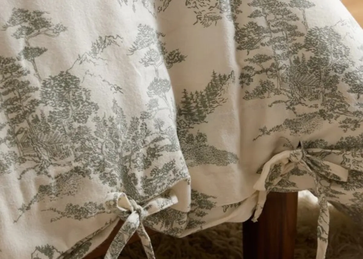 A closeup lifestyle image of the Eve toile duvet set wih a focus on the ties instead of button detail