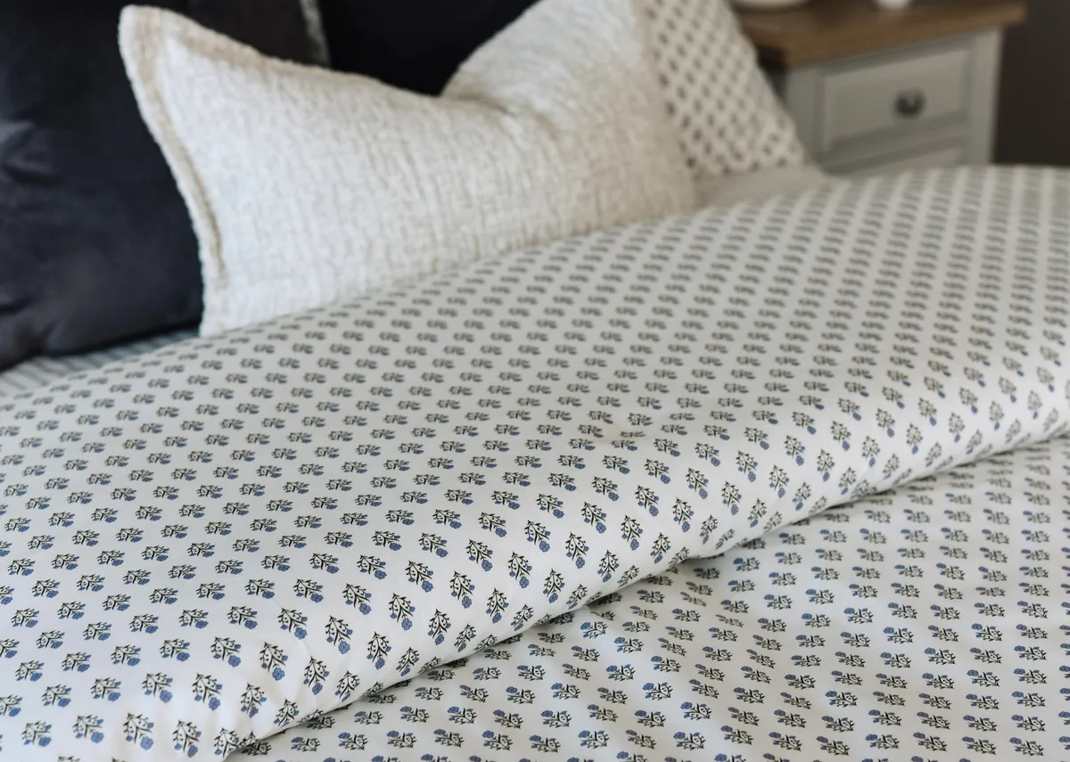 A lifestyle image of the Foxford Emma duvet set on the Ebony bed witha selection of cushions.