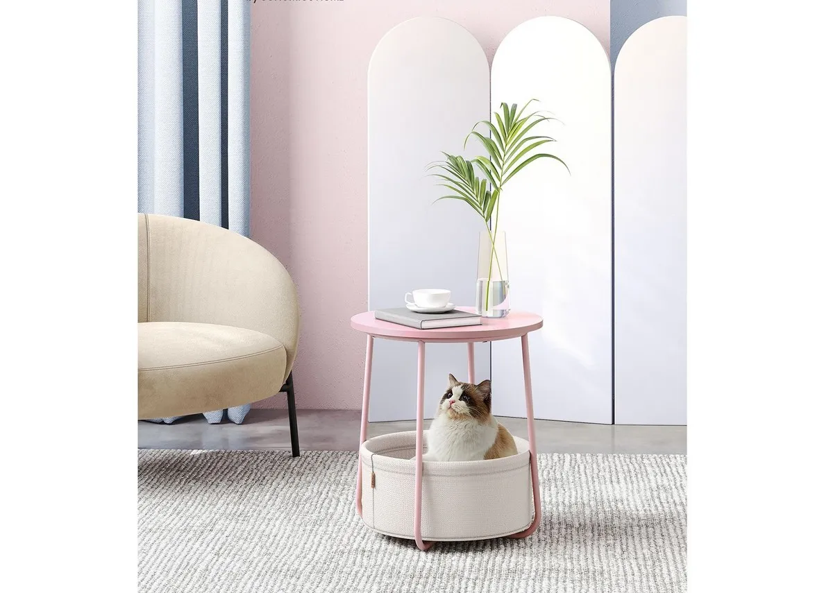 A lifetsyle image of the Blossom table with a cat in the basket and plant and cup on tabletop