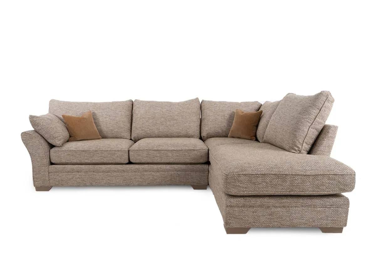 A beige fabric corner sofa with chaise on left from EZ Living Furnitures Strata range. Front view of side cushions and oak feet.