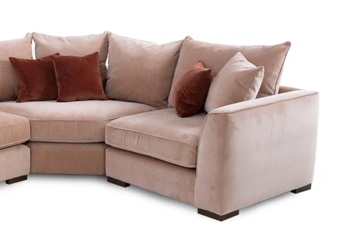 An LAF pink fabric corner sofa with rust cushions from Lucius range. Closeup of corner and arm finish.