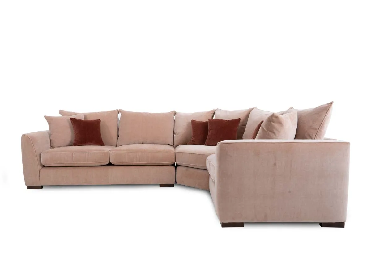 An LAF pink fabric corner sofa with rust cushions from Lucius range. Side view of 2.5 seater