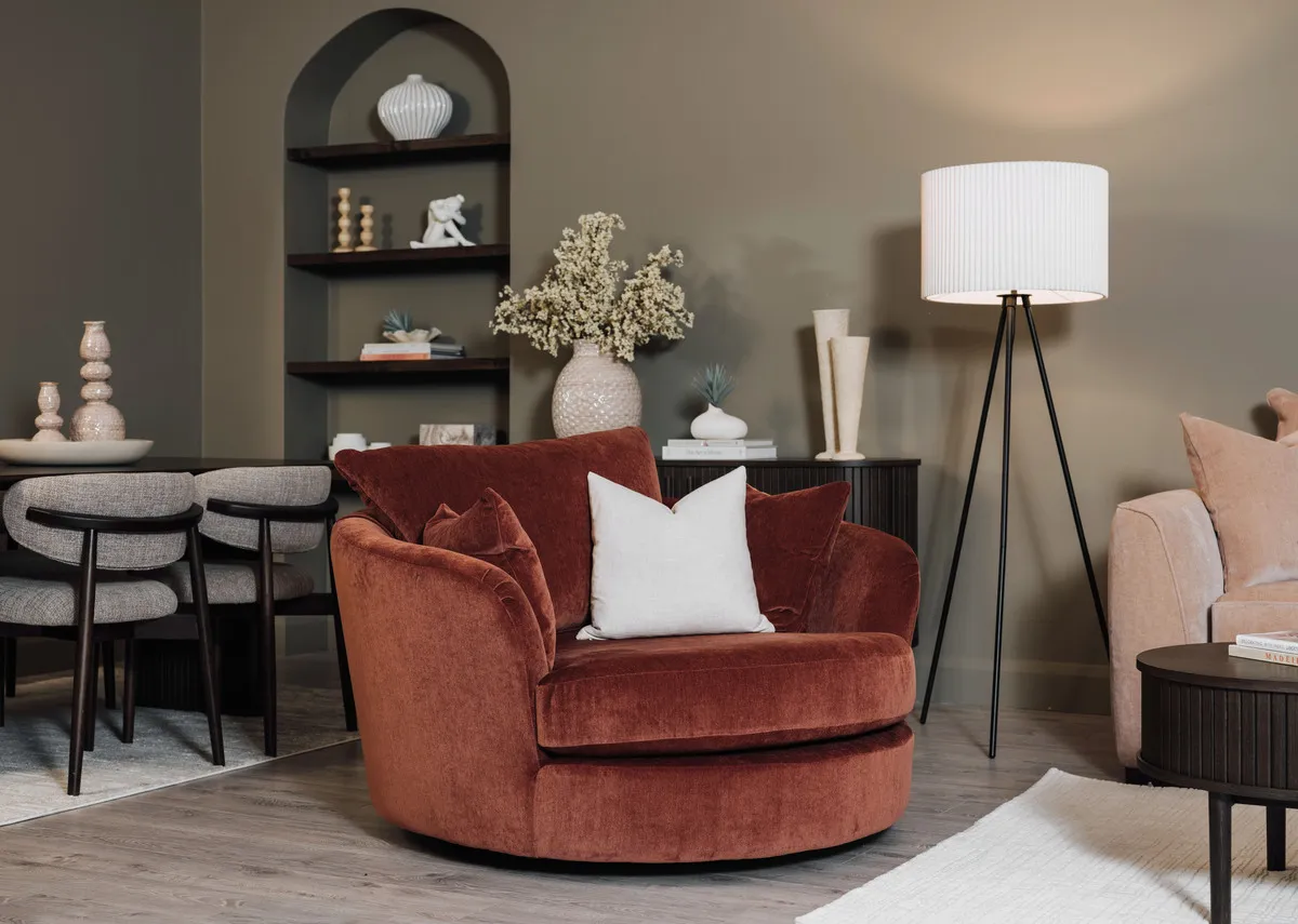 A lifestyle image of the Lucious swivel cuddler with Nola table in espresso and Starlete lamp.