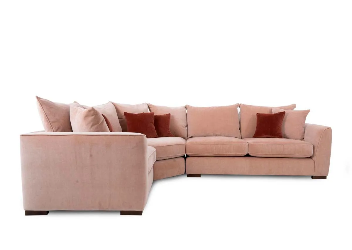 An RAF pink fabric corner sofa with rust cushions from Lucius range. Side view of 2.5 seater