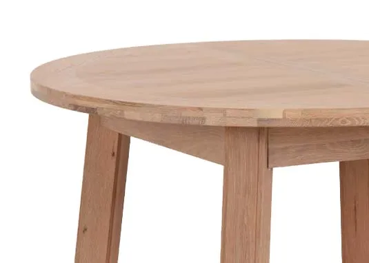 A round oak dining table from EZ Living Furnitures Albany range. Closeup of curved textured tabletop.