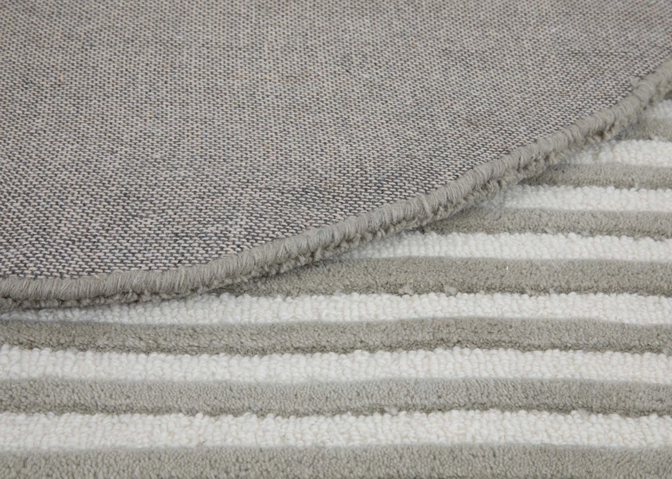 A green grey and navy abstract shaped rug from EZ Livings Geo range. Closeup of grey ribbed pile.