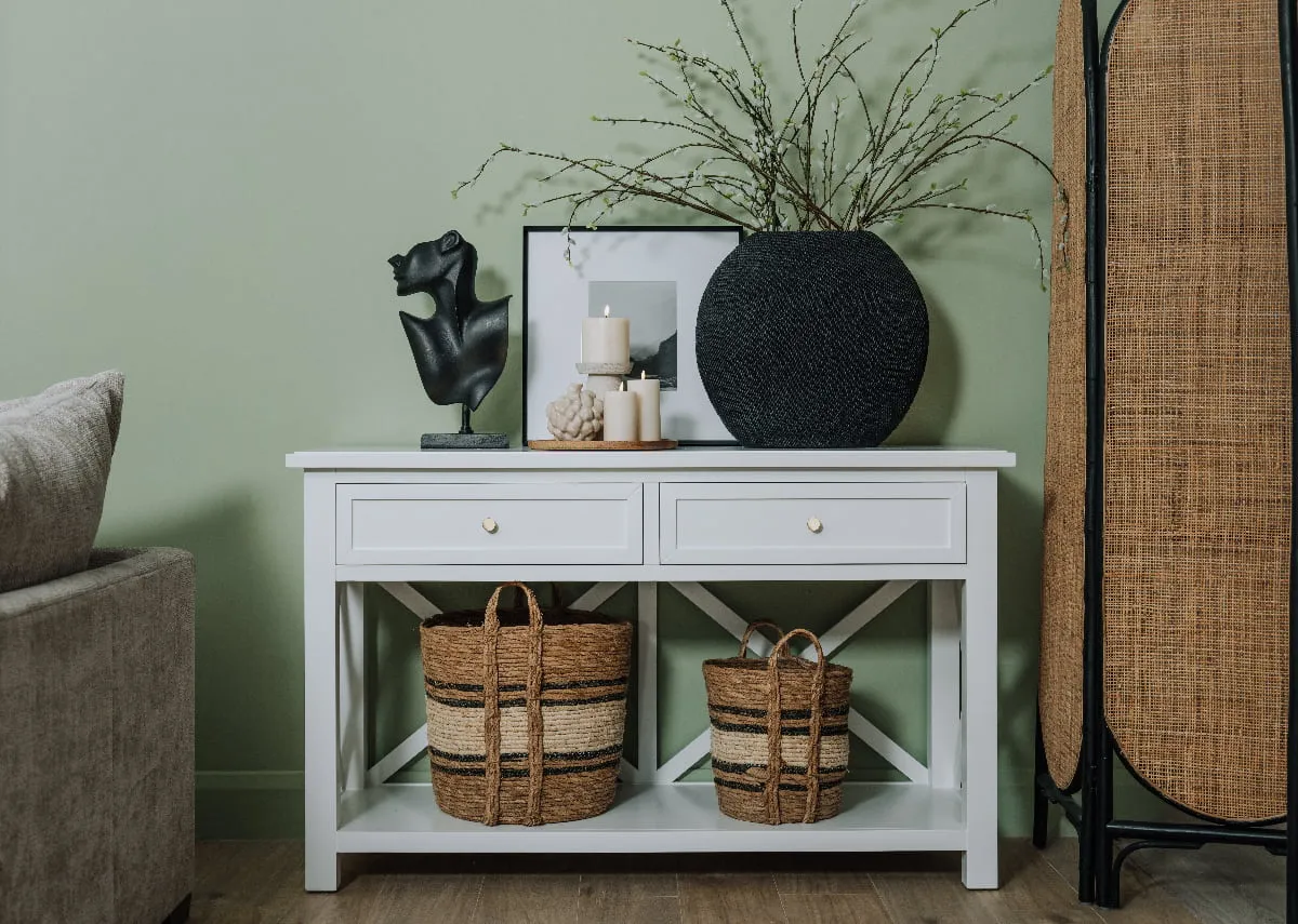 A lifetsyle image of the Hampton Console with 2 baskets on shelf and ornament