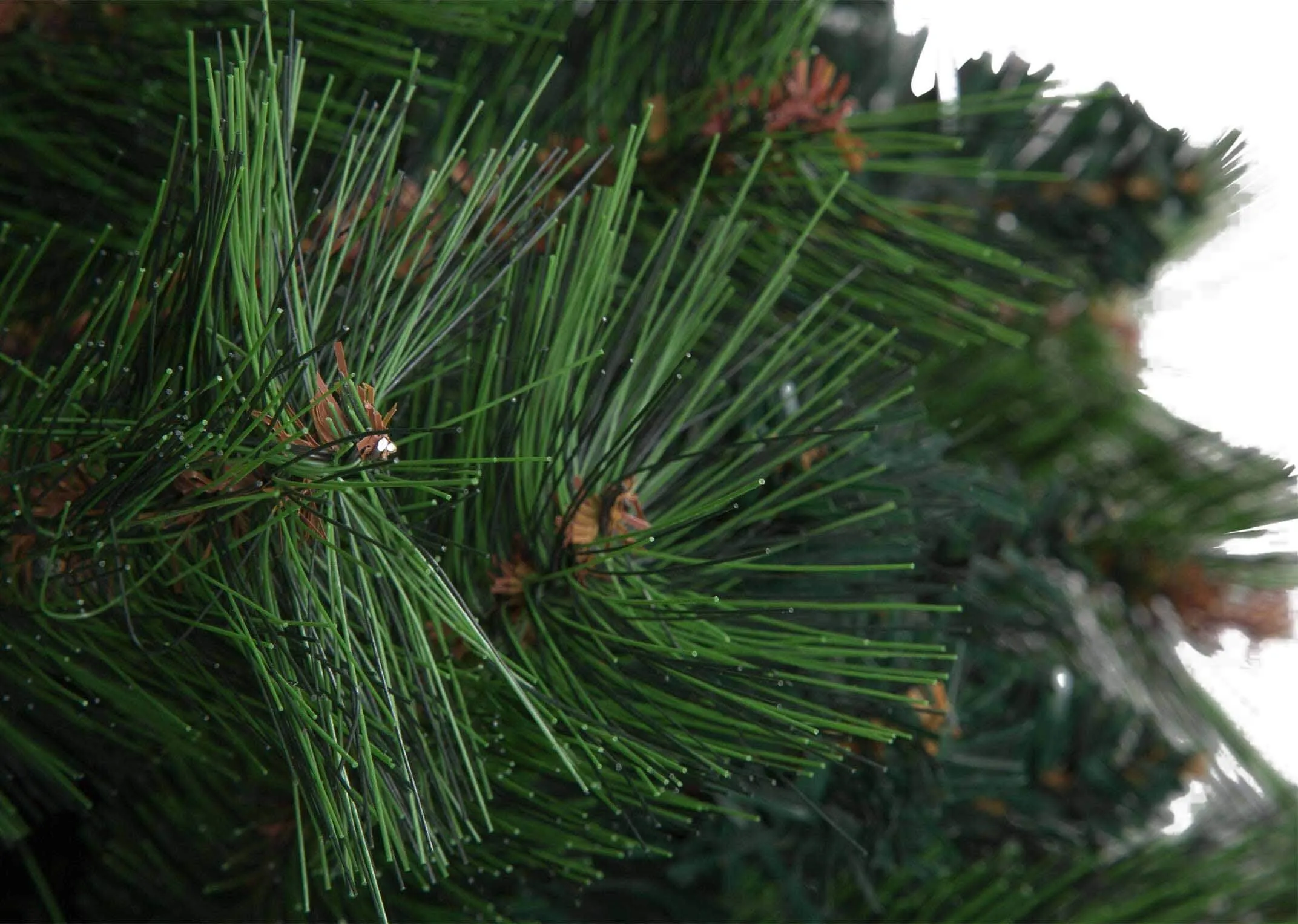 A close up of the top of the 180cm pine Christmas tree highlighting the green faux needles.