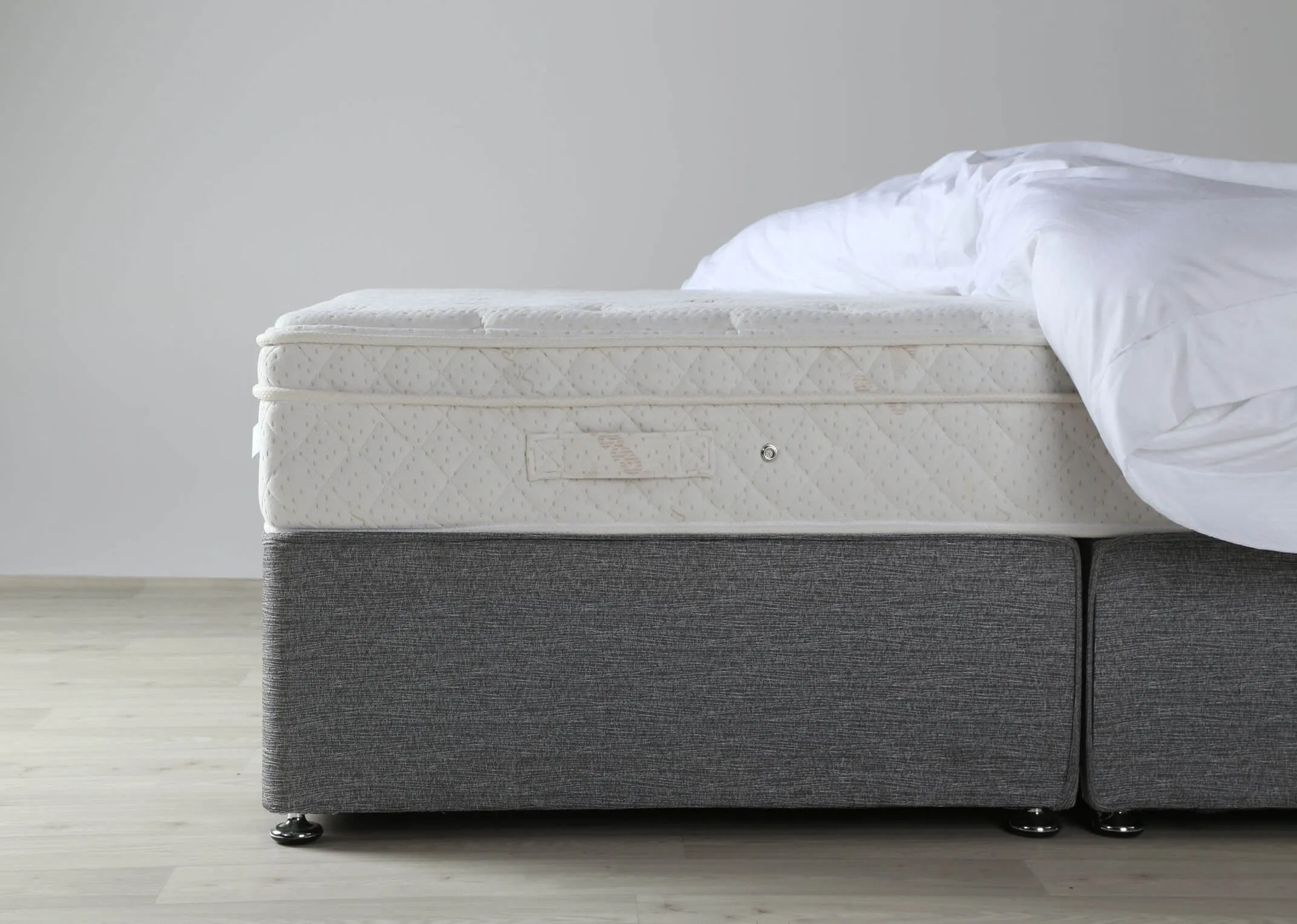 A lifestyle image of the Majesty Cashmere Mattress on the Venice divan with Shiraz Occasional chair & Okno floor lamp.