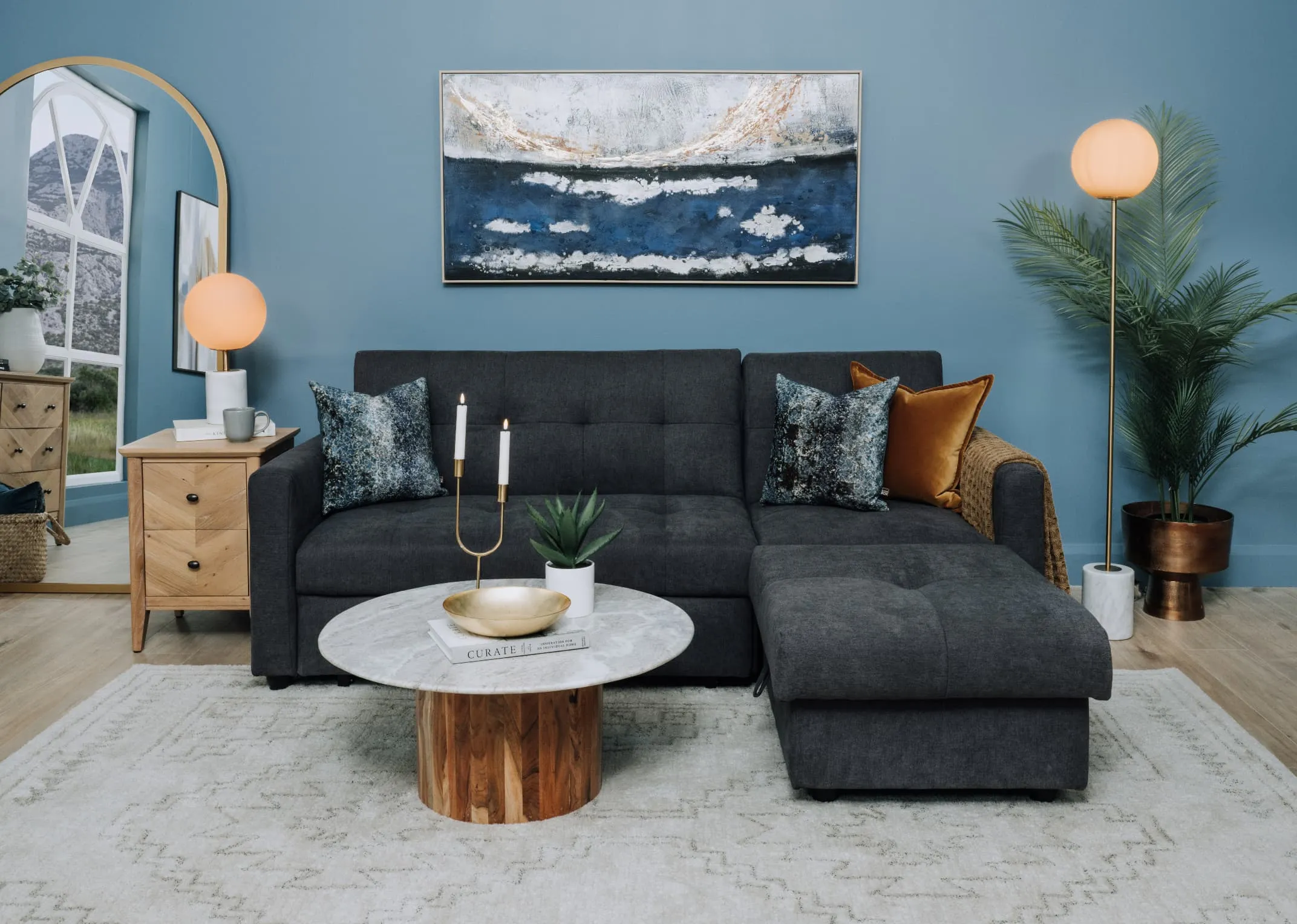 A lifetsyle image of the Dalkey sofabed as a bed with chevron side lockerCauley coffee table and Captivating canvas.