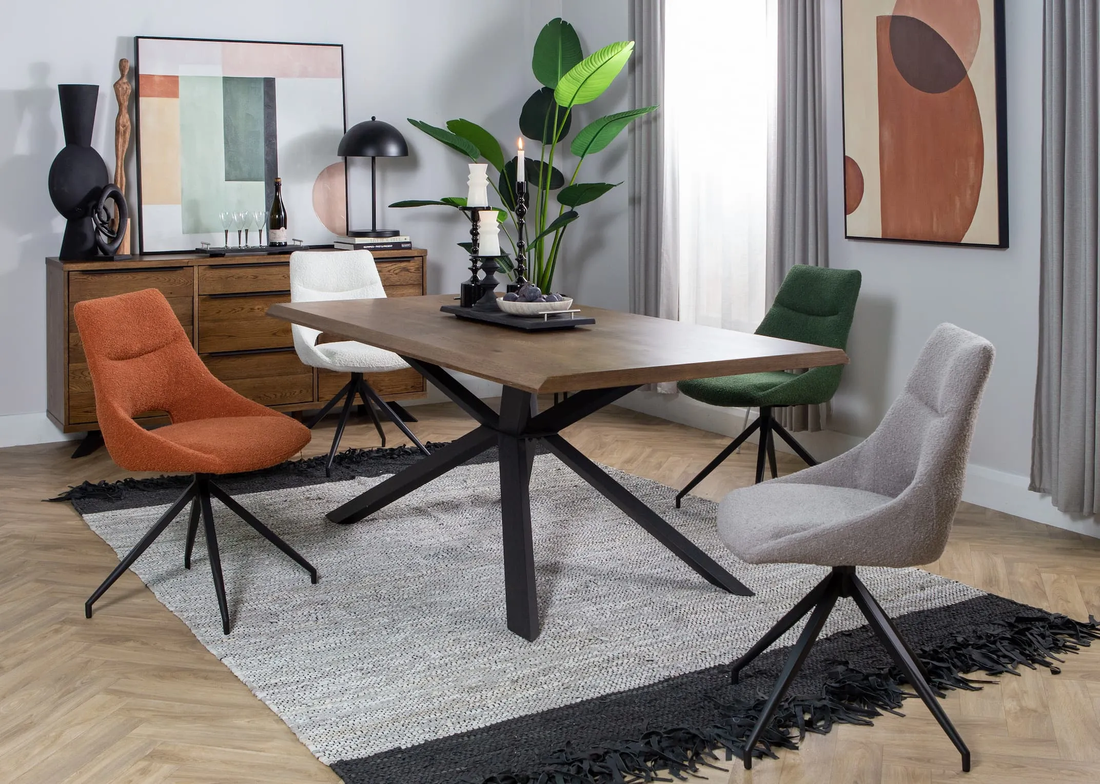 A lifestyle image of the Arno smoked oak dining table with Cobh boucle dining chairs in rust