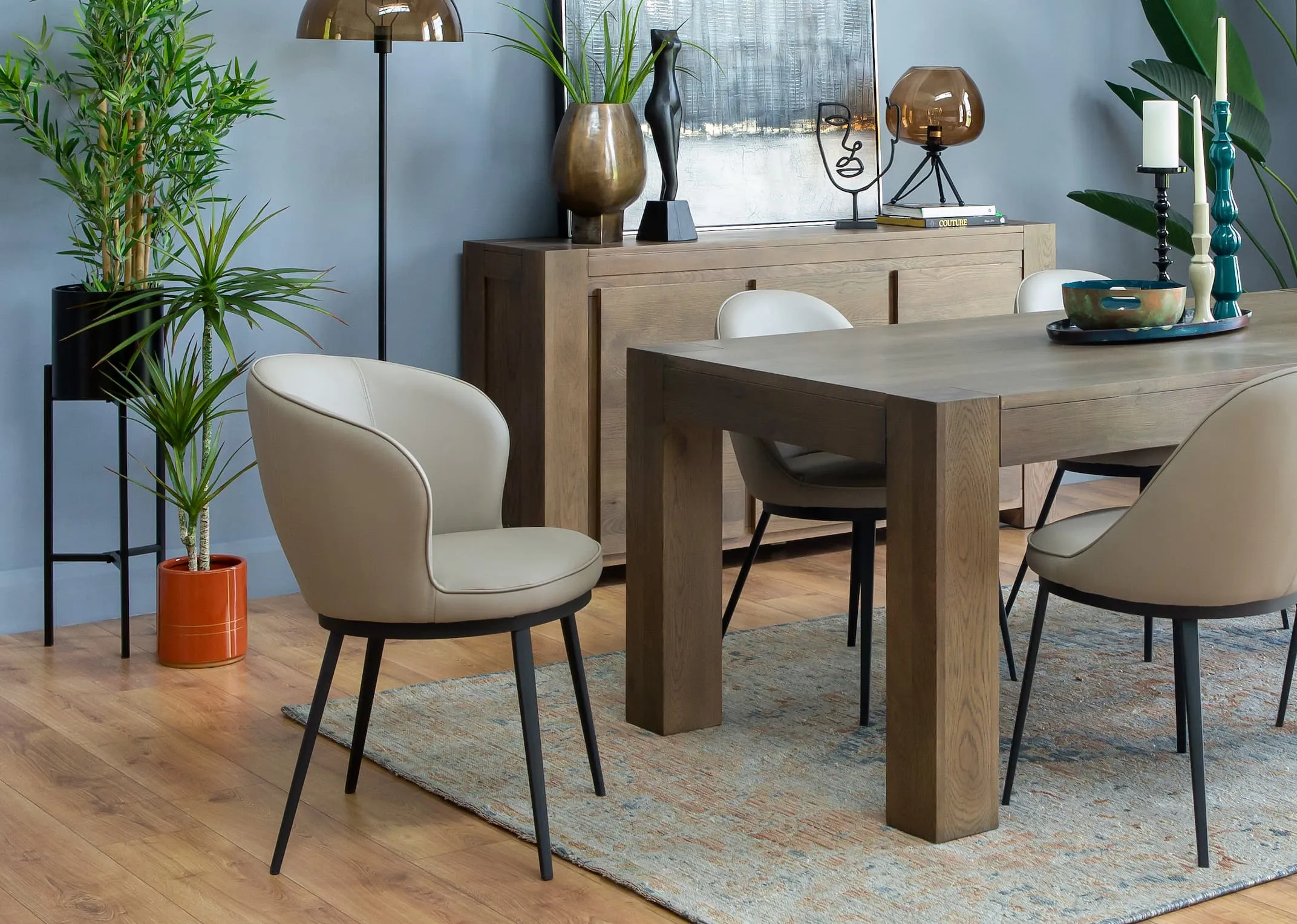 A lifestyle image of the Morgan Dining table with Gain chairs & Yucca plant in a suus pot holder.