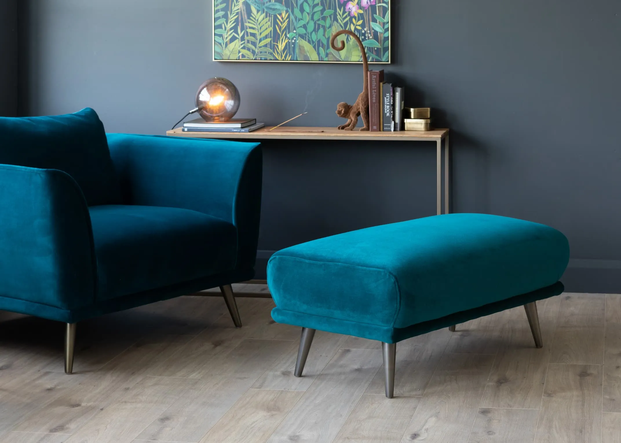 A lifestyle image of the Katie cuddler & footstool with rainforest canvas & aston console.