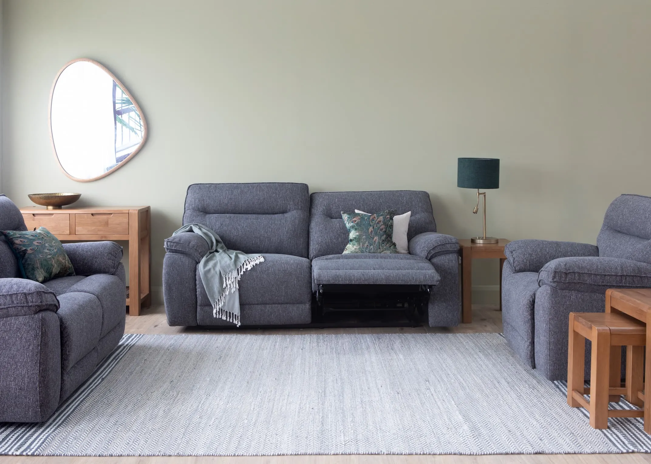 A lifestyle image of the Cairms Grey Fabric Sofa range with Tiverton lamp