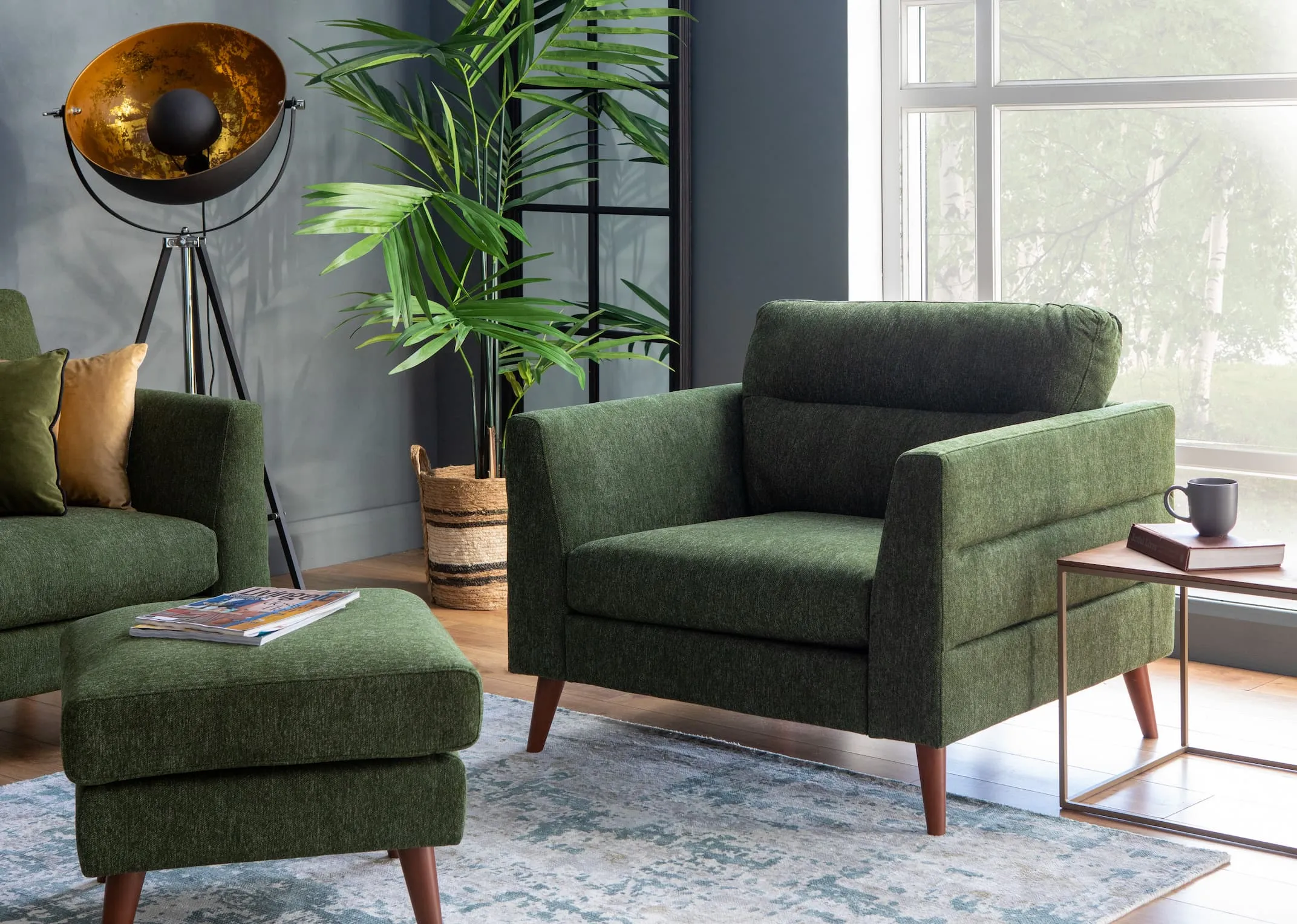 A lifestyle image of the Presley Armchair & Footstool with Modesto rug & Cosmos lamp.