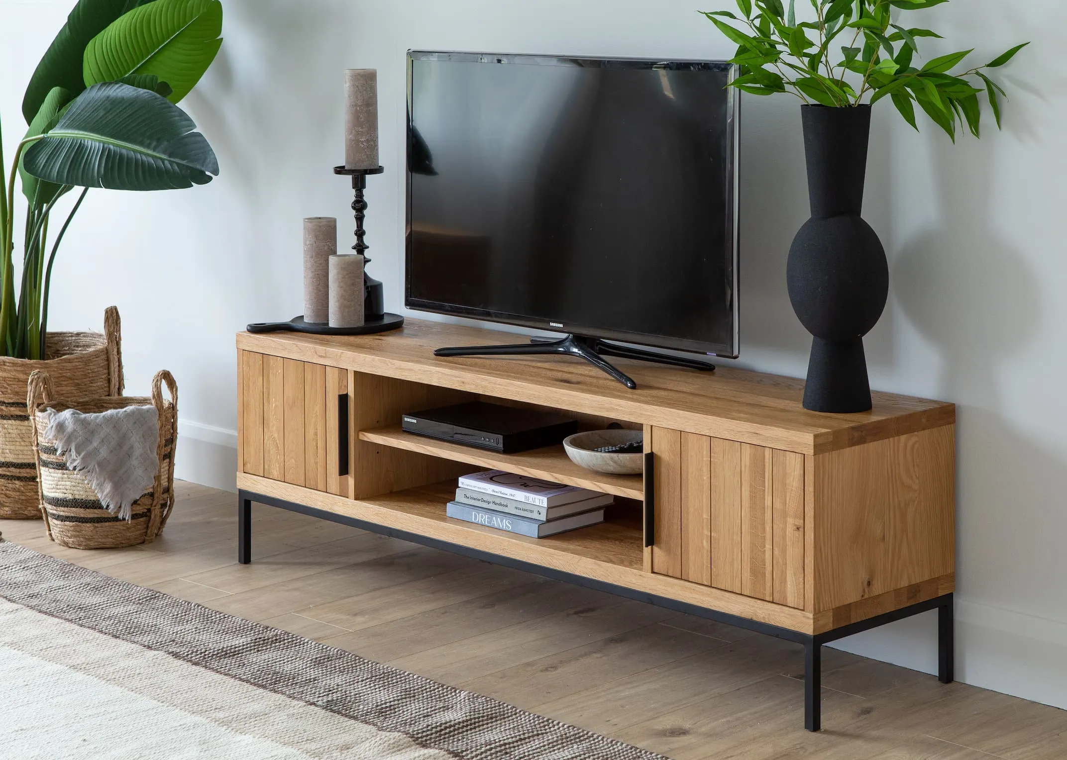 A lifestyle image of the Renvyle Med TV Unit styled with a tv