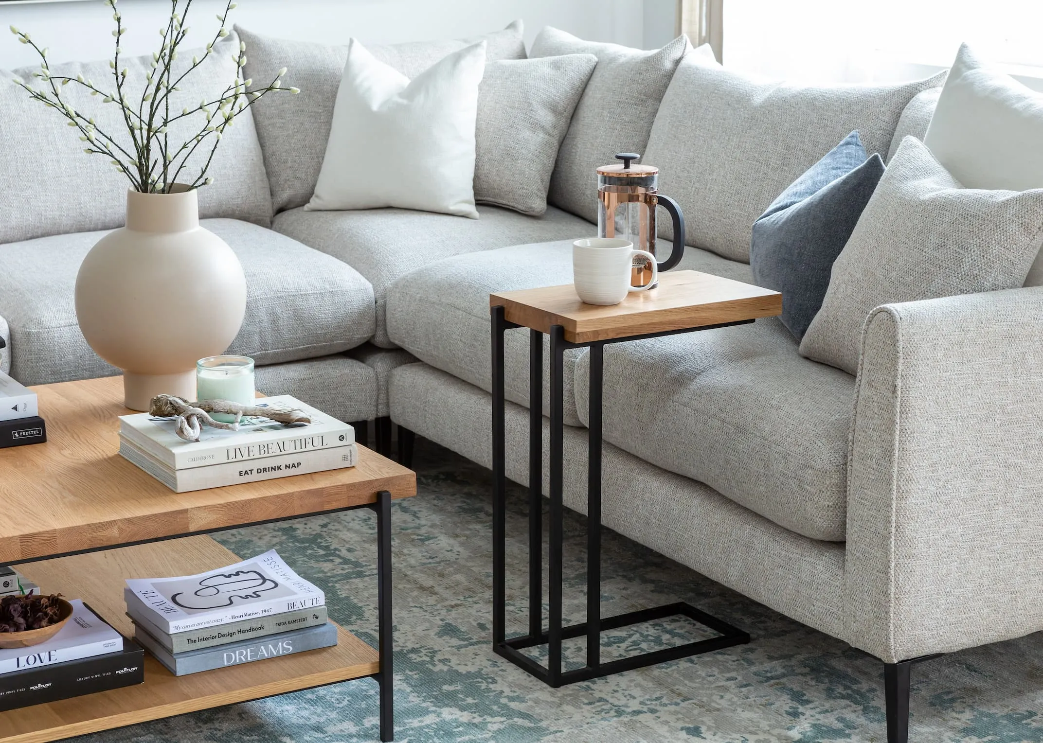 A lifestyle image of the side table clipping onto the side of the Hunter Corner sofa