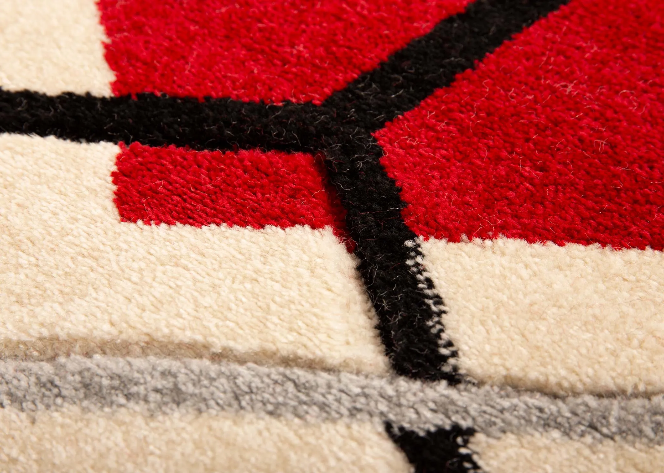 A cream rug with grey and deep red octagon pattern design from EZ Livings Forma range. Closeup of texture