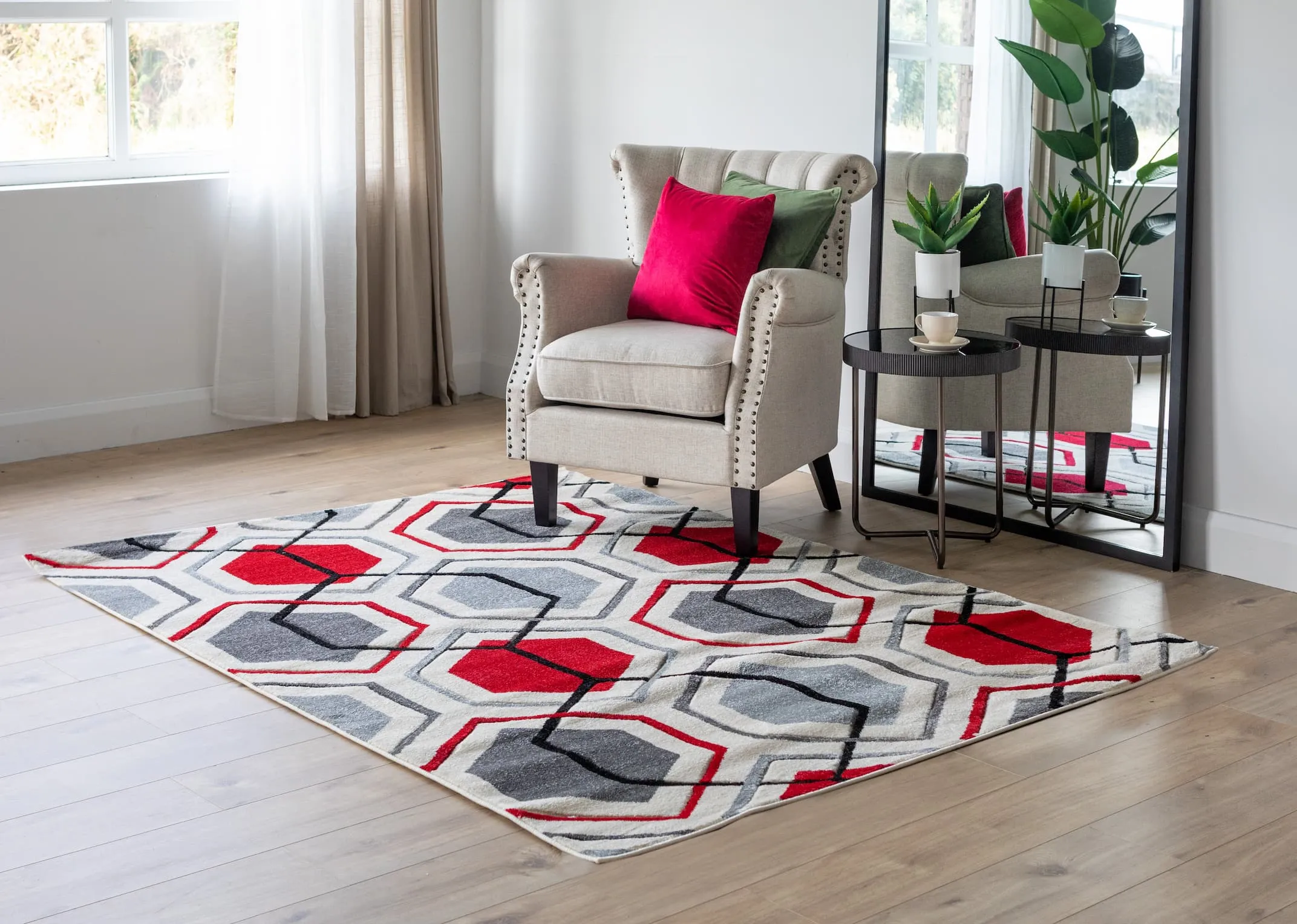 A lifestyle image of the Forma red rug with the Sara linen armchair with Mandy table & Chrisley mirror.