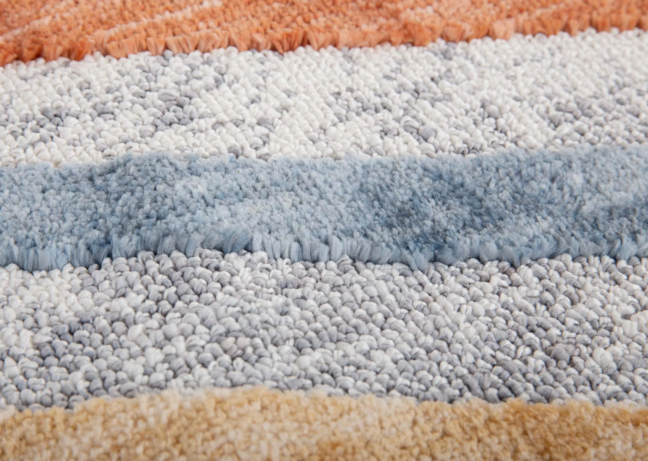 A grey rug with red yellow blue and white stripes in 2 x shapes from EZ Livings Gatsby range. Closeup of stripes on short pile