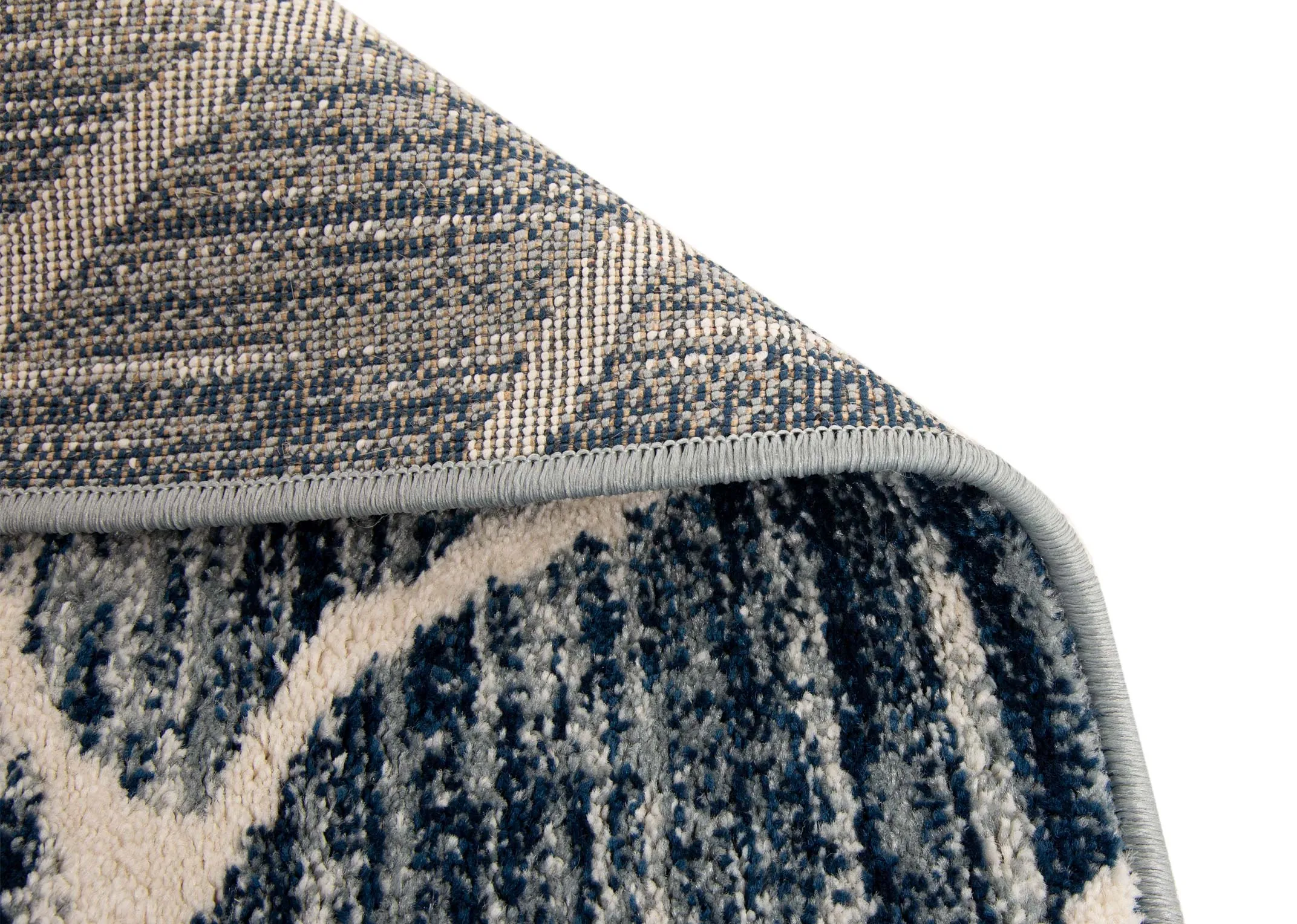 A navy blue rug with cream cracked pattern from EZ Livings Grotto range. Closeup of underlay