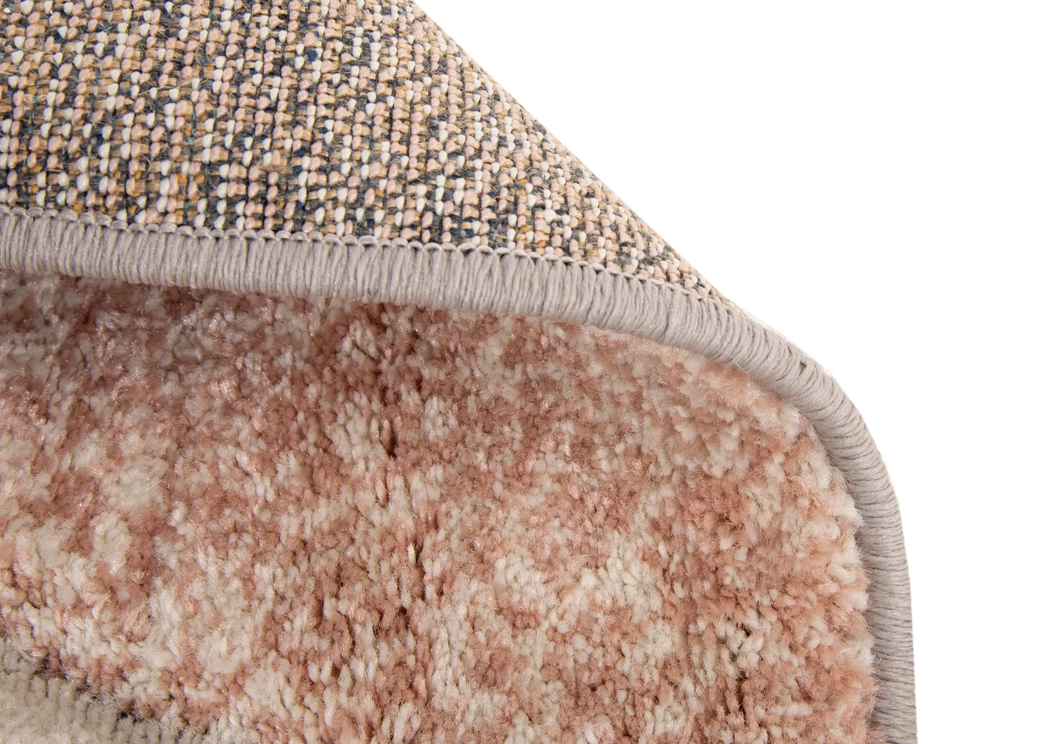 A cream rug with blush pink & grey quart circular shapes from EZ Living Furnitures Holden range. Closeup view of underlay