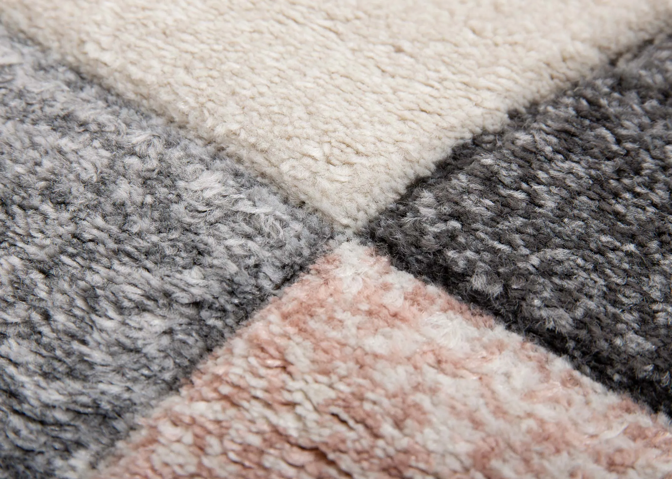 A cream rug with blush pink & grey quart circular shapes from EZ Living Furnitures Holden range. Closeup of thread and texture
