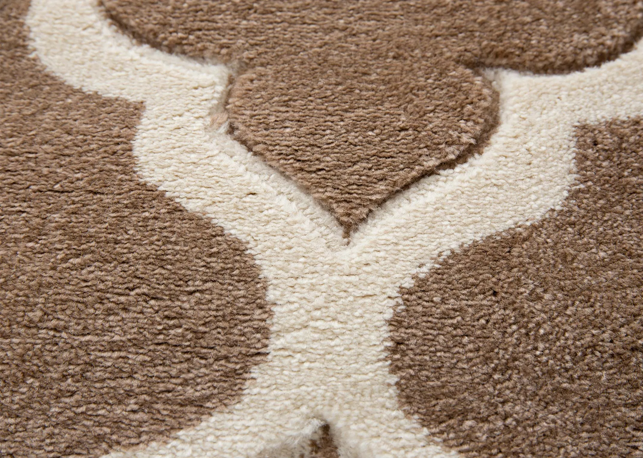 A dark beige rug with cream trellis design from EZ Livings Delia range. Closeup of soft texture
