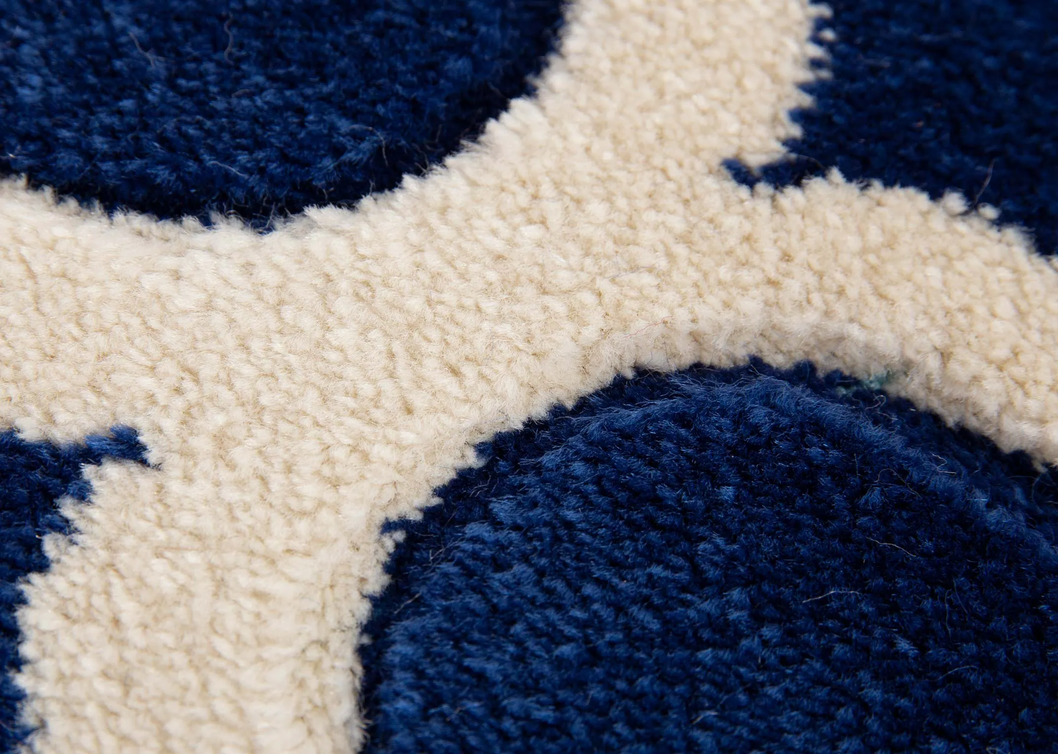 A navy blue rug with cream trellis design from EZ Livings Delia range. Closeup on textrue and soft pile
