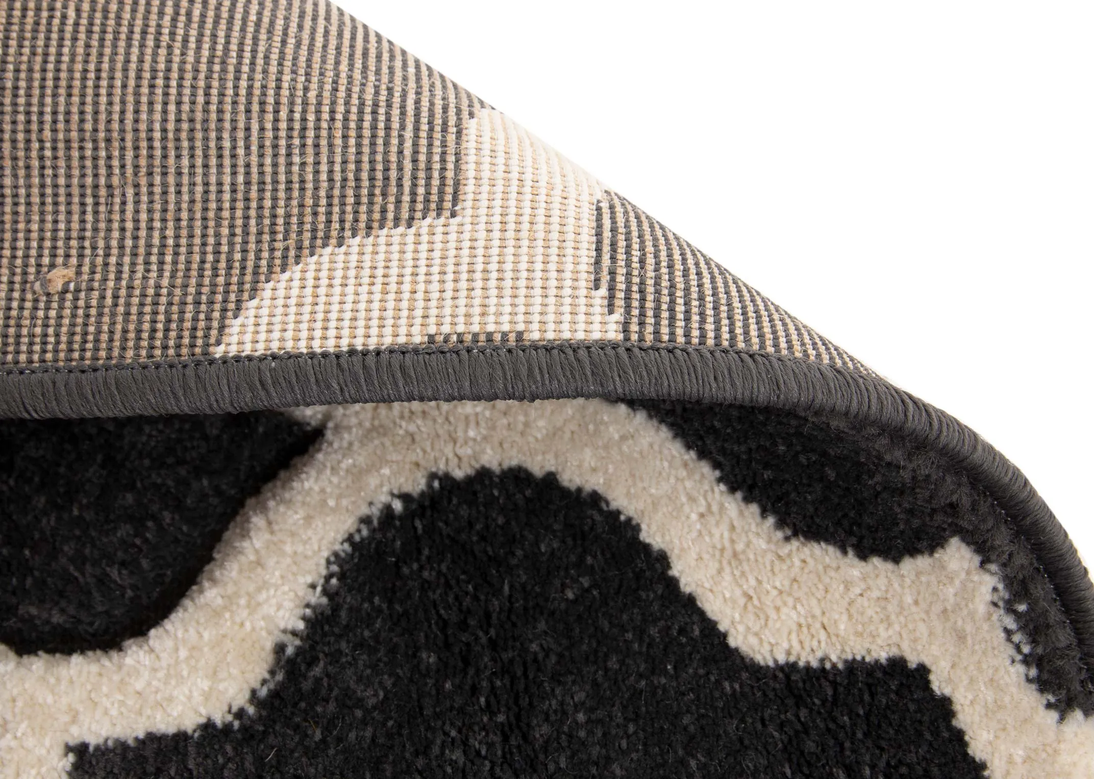 A dark grey rug with cream trellis design from EZ Livings Delia range. View of cream underlay
