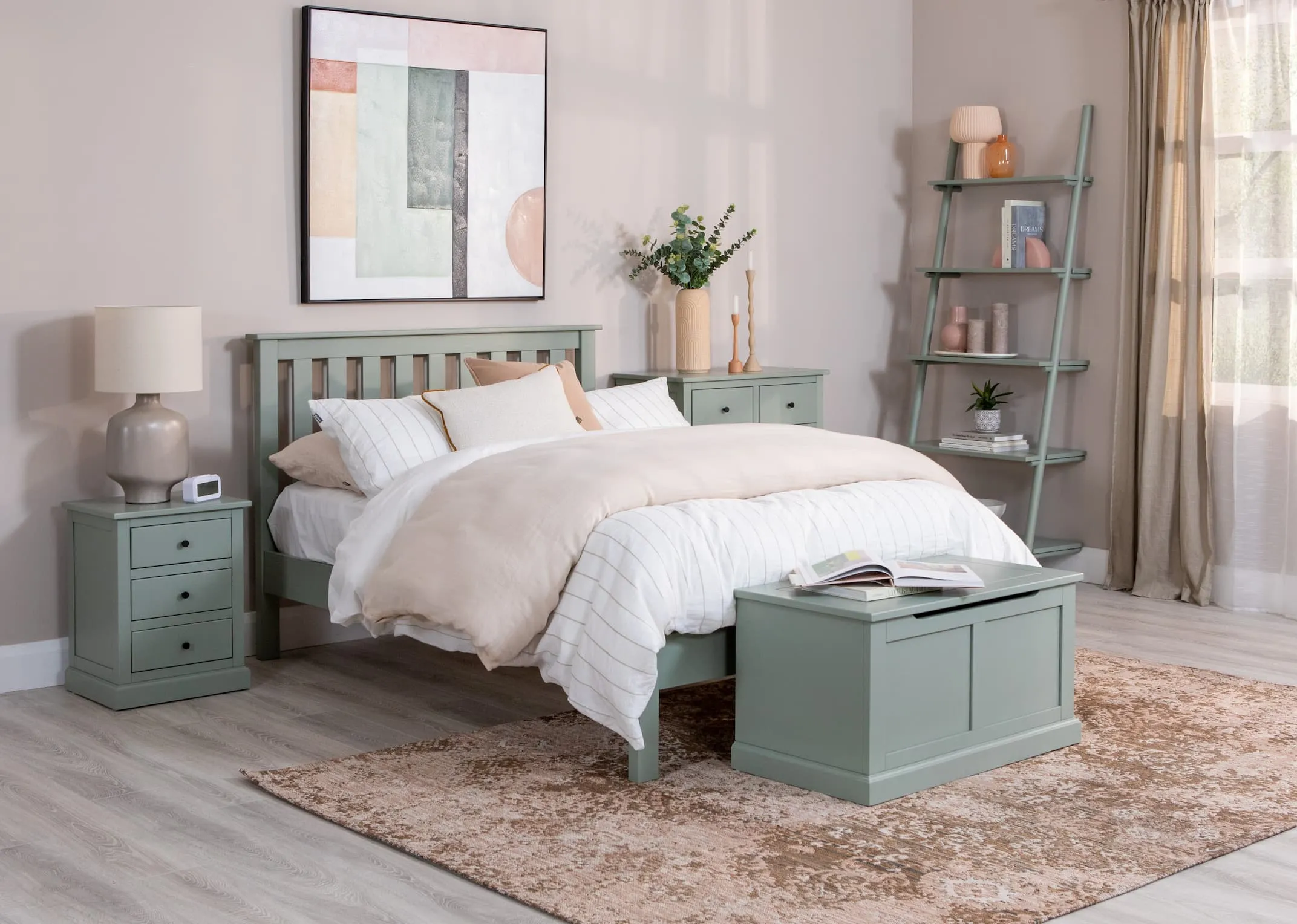 A lifestyle image of the Green Atlas locker with Retro lamp & the matching bedframe and blanket box from Atlas with the Step green bookcase.
