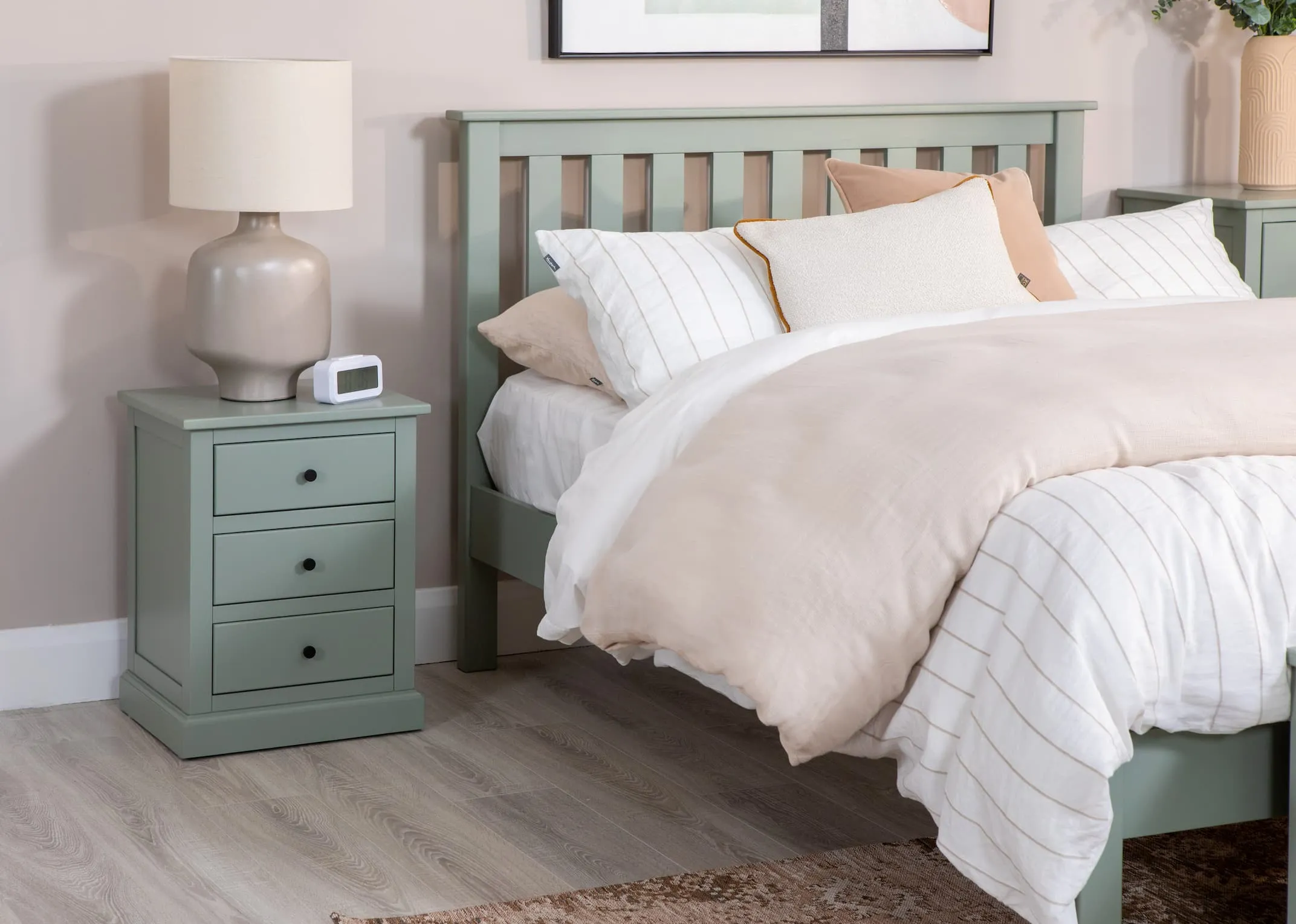 A lifestyle image of the Green Atlas locker with Retro lamp & the matching bedframe and blanket box from Atlas with the Step green bookcase.