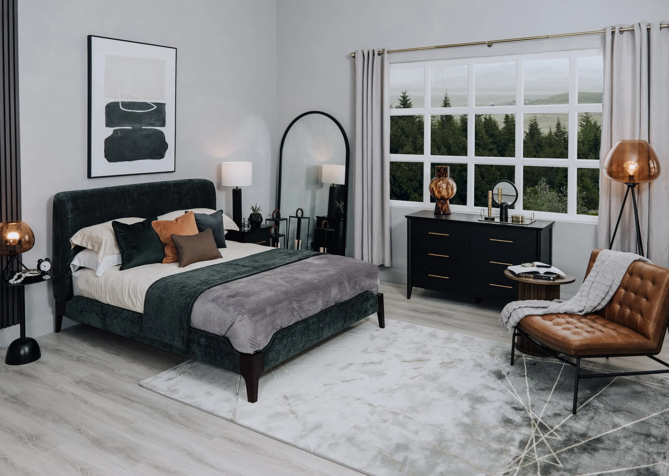 A lifestyle image of the Calm green bedframe with a selection of cushions and the chevron chest and Madrid lounge chair.