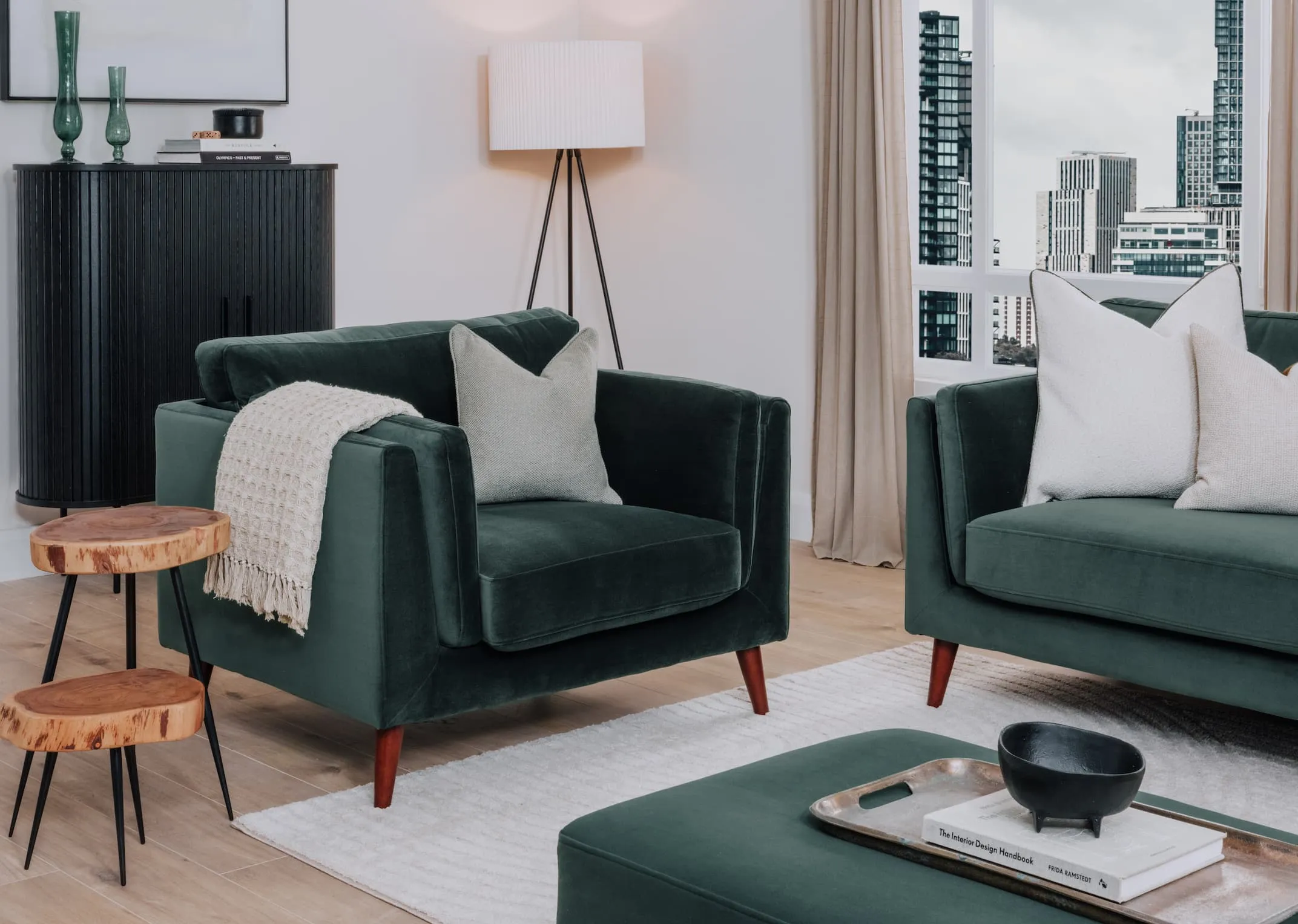 A lifestyle image of the Metal floor lamp with Green Bellini armchair and footstool with Nola black cabinet.