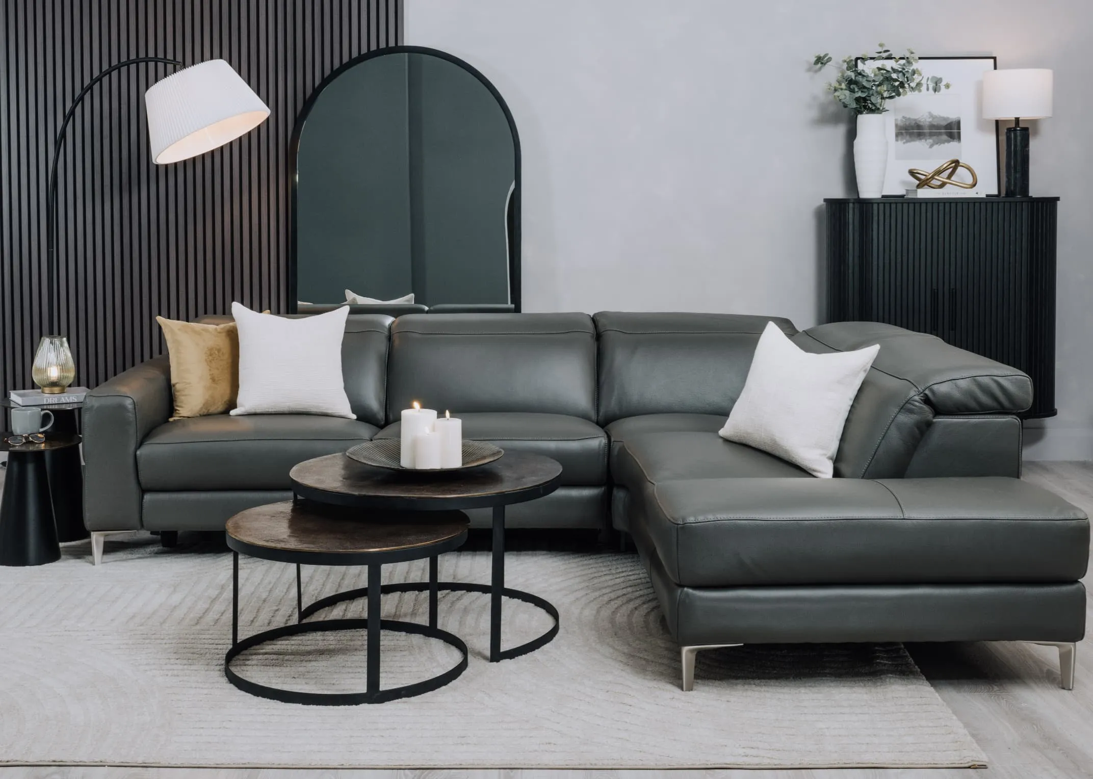 A lifestyle image of the Vancouver sofa with toko tables and Chrisley mirror with Arc floor lamp.