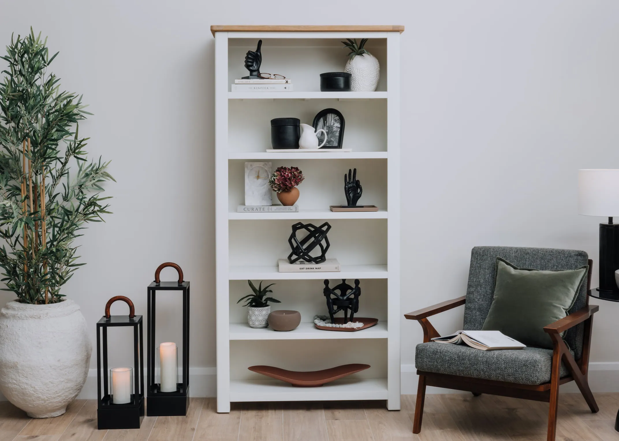 A lifestyle image of the Barleycove bookcase with a selection of ornaments including the Black marble thumbs up.