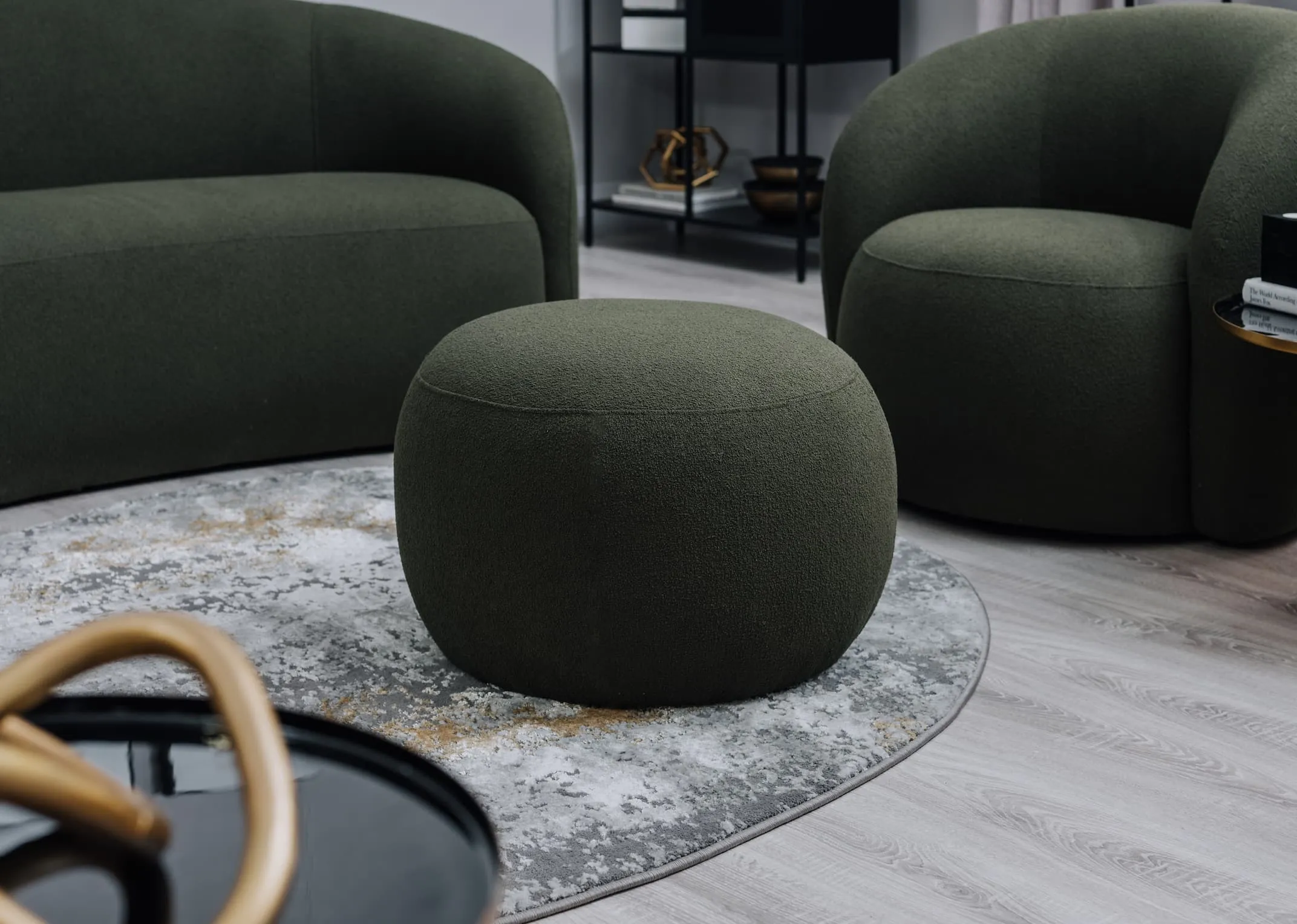 A lifestyle image of the Florance green pouffe with matching sofa on Ritz rug.