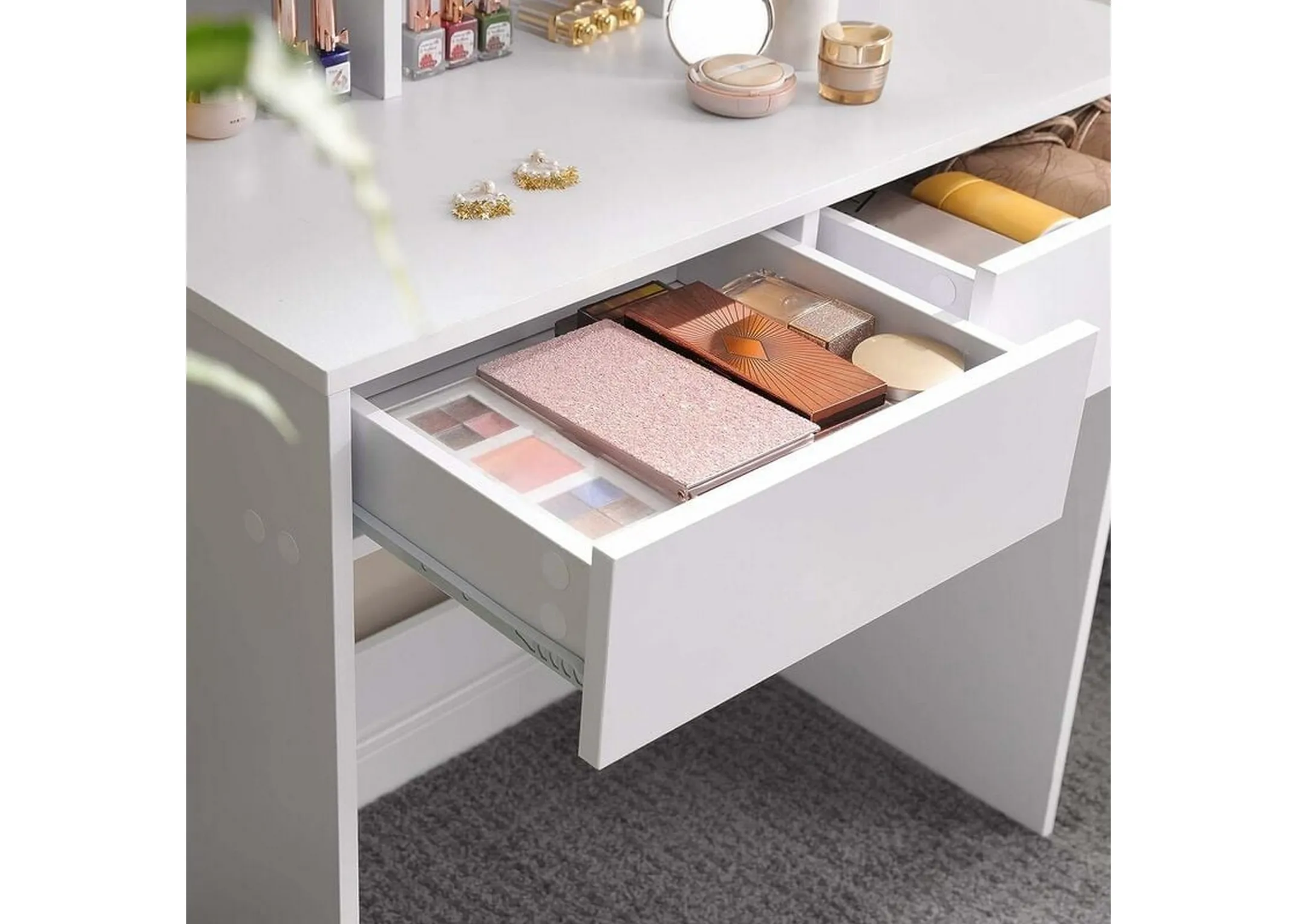 A lifestyle image of the Nami dressing table with drawers open to show space for cosmetics.
