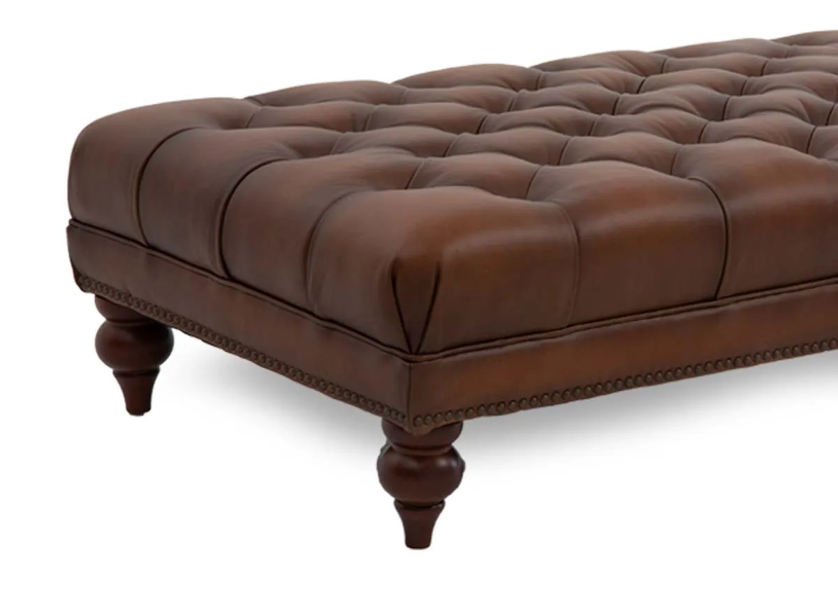 A tufted button brown leather footstool from EZ Livings Adare range. Closeup of pedestal feet