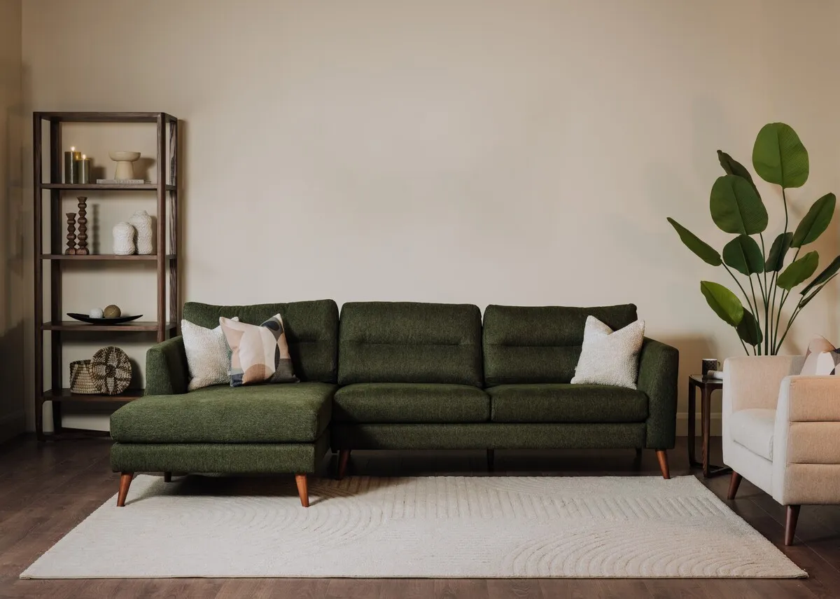 A lifestyle image of the Presley green fabric corner chaise with Cameo bookcase.