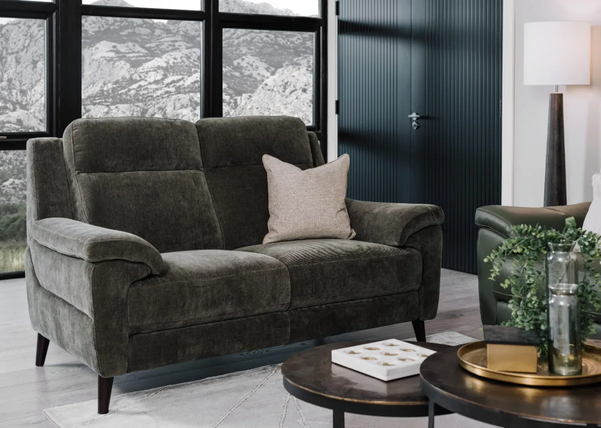 A lifestyle image of the Elliot 2 seater green fabric sofa with the Toko nest of tables
