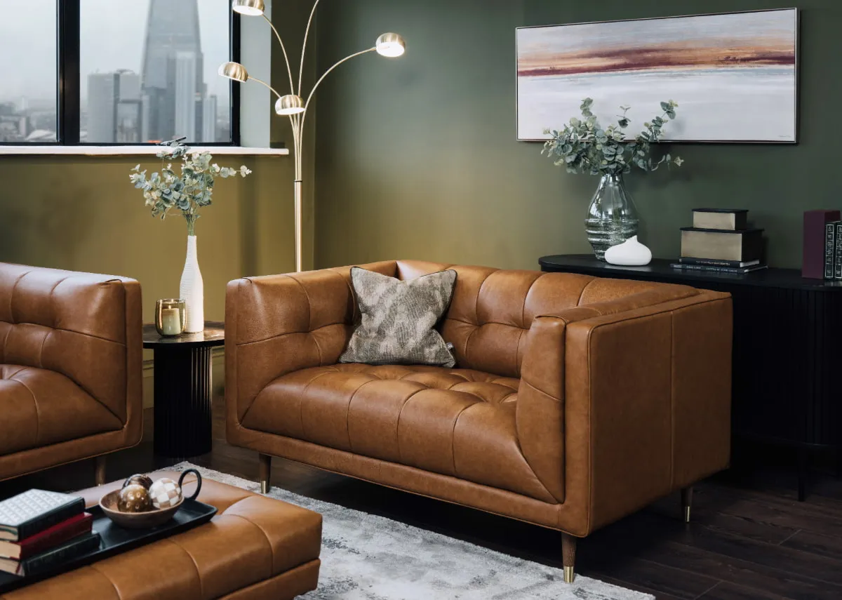 A lifestyle image of the Grace tan leather 2 seater with nola black sideboard and grace footstool.