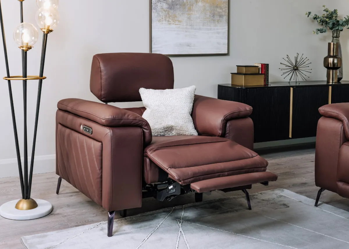 A lifestyle image of the Paige recliner fully reclined with cream cushion with Ortez floor lamp
