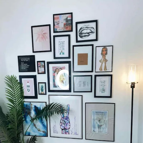 Painted white gallery wall with photo frames.