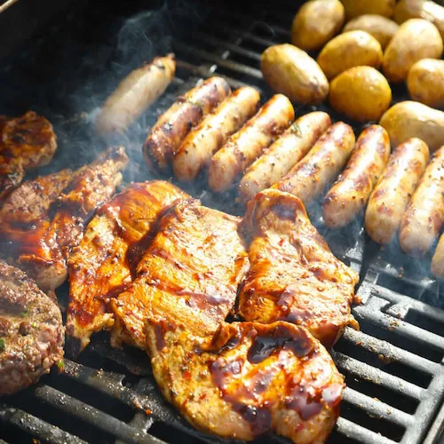BBQ in a box meat and potatoes cooking on a BBQ.