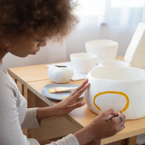 Woman painting pottery.